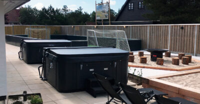 To udespa på terrassen i et kæmpe luksuriøst feriehus. Begge spa er model Comfortana pro, leveret med cover og coverlift|DuoLine biler med trailere er klar til at køre ud med to Comfortana udespa. Det er tidlig morgen, så solen er kun lige på vej frem.|Placering af udespa på terrasse ved luksus udlejningshus. To x Comfortana pro udespa leveres her via kran.|Udespa trailer for levering af to x comfortana pro udespa i Blåvand. Her er de ved at være klar til at køre afsted fra DuoLine domicil.|Kranlevering af Comfortana udespa. En udespa af to hænger i luften og er igang med at blive placeret ved sommerhus.