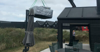 Spa leveres med kran ved sommerhus. Levering og montering af udespa til udlejning - model Comfortana Pro.|Fliseterrasse til spa er ved at være klar. Husk at der skal være vand og strøm til karret. Levering og montering af udespa til udlejning|Spabad klar til levering. Her er den sat på kranen, så den kan blive hest hen over et hustag. Levering og montering af udespa til udlejning