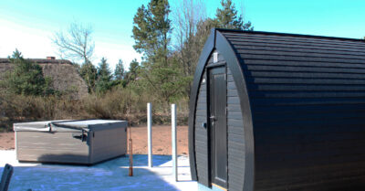 Saunahytte deluxe og spa ved sommerhus i Blåvand. Når først beplantning vokser op, er dr sikret en fantastisk udendørs wellness plads.|Saunahytte Deluxe placeret på terrasse ved nyrenoveret feriehus og med direkte adgang til udebrus og lækkert udendørs spabad.