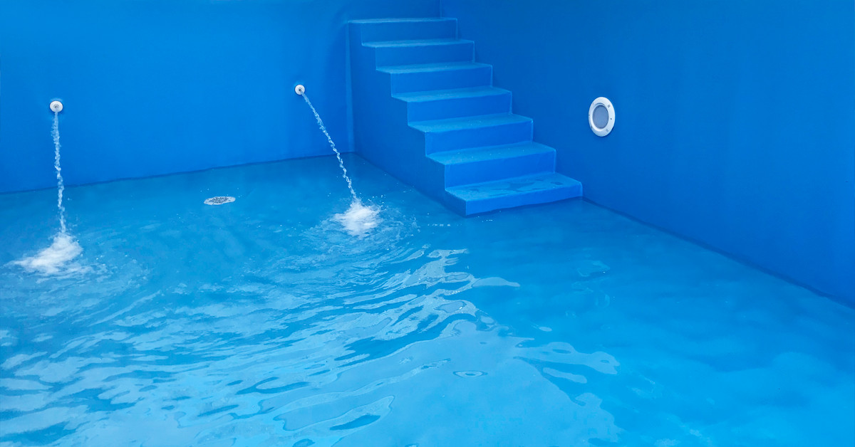 Dyser i swimmingpool. Der er monteret en ny azurblå folie i bassinet og dyserne er i gang med at påfylde vand.