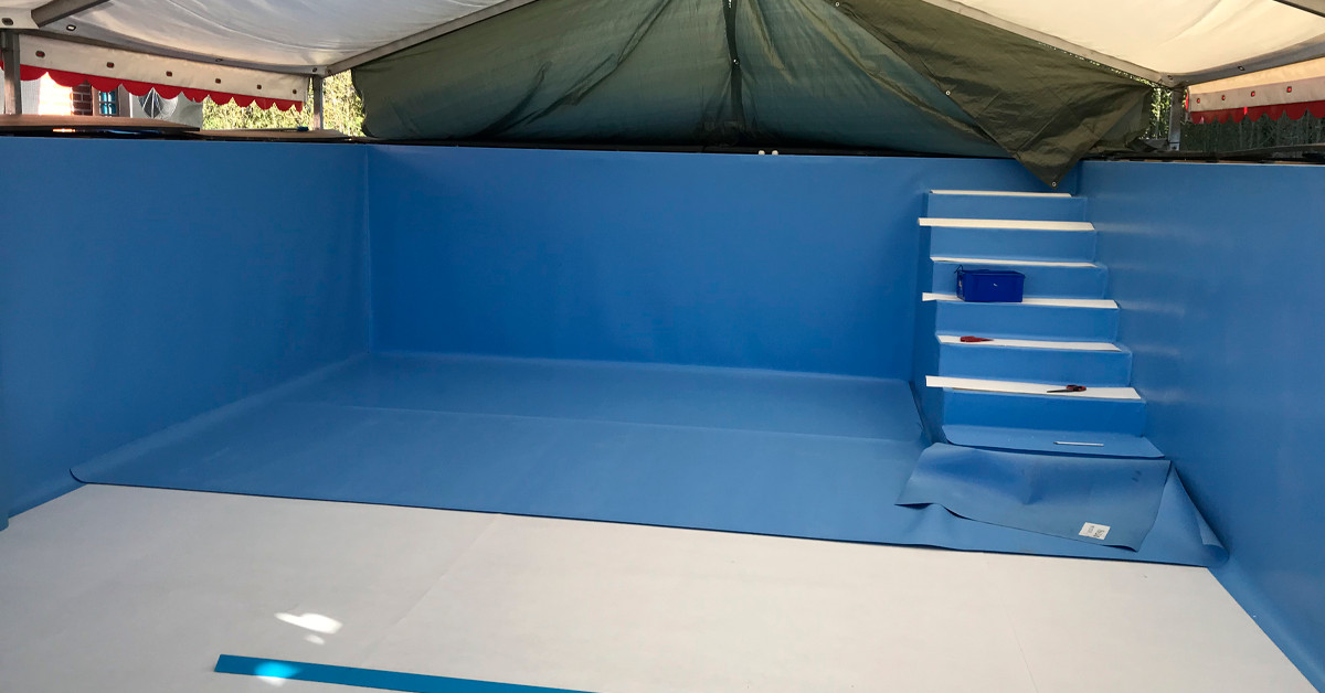 Folieskift under telt. Grundet foranderlige vejrforhold er der sat et telt op over swimmingpoolen, hvor der svejses ny folie på.