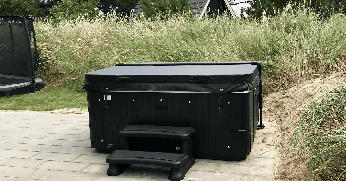 MaXXwell udespa med cover model laidback i flot sort teint og trappe. Den udendørs spa er beregnet til udlejningshuse.