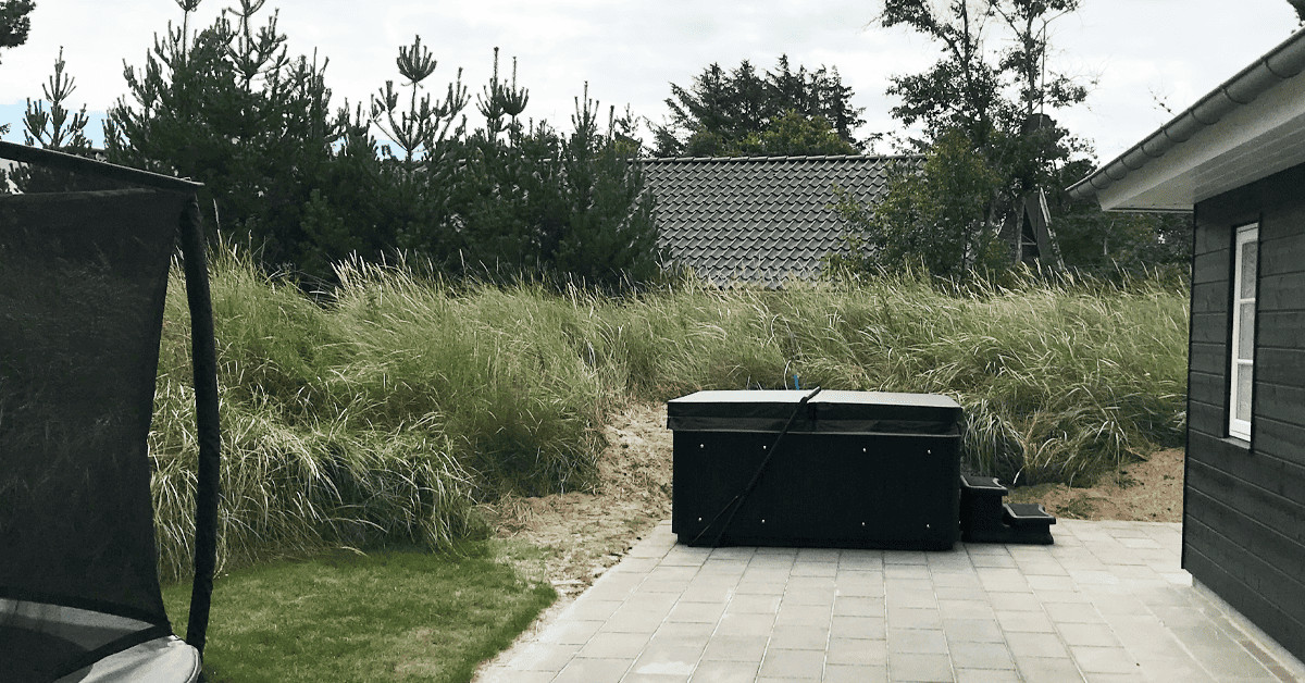Sort udespa på terrasse ved sommerhus. En MaXXwell Laidback er leveret og monteret og passer flot til huset.