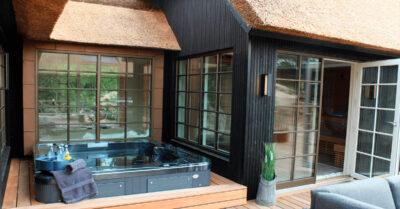 Udespa og wellnessafdeling. En hel fløj i sommerhuset er dedikeret til velvære. Spaen er indbygget i terrassen har direkte adgang til sauna og dampbad.|Spa på terrassen - En Comfortana Pro udespa er nedsænket på terrassen ved sommerhus med wellness afdeling|spa i vindfang ved sommerhus med wellness afdeling|Wellnessafdeling i udlejningshus. Hængestolen har udsigt til dampbad og sauna med infrarøde paneler.|Søjleovn i sauna. Søjleovnens stentårn står flot i saunaens hjørne og bliver del af interiør. Klar til afslapning med vin og varme.|Spa til udlejning. Comfortana Pro udespa er installeret i en stille krog i et udlejningshus. Spaen er fyldt op og klar til gæster.|Styrepanel til sauna og damp monteret på væggen i wellness afdelingen. Det betyder central og nem styring af varme og damp.|Hvide sten i dampkabine. Stenene er lagt i forbindelse med dampudsivning og giver en flot æstetik i kabinen.|Vin og afslapning i sauna og dampbad. En flaske vin og to glas har fundet vej til den infrarøde sauna i udlejningshus med wellnessafdeling.|Isbad monteret på væggen, så det er muligt at få et koldt gys efter turen i sauna og damp kabinen. Virker ved et enkelt hiv i snoren.