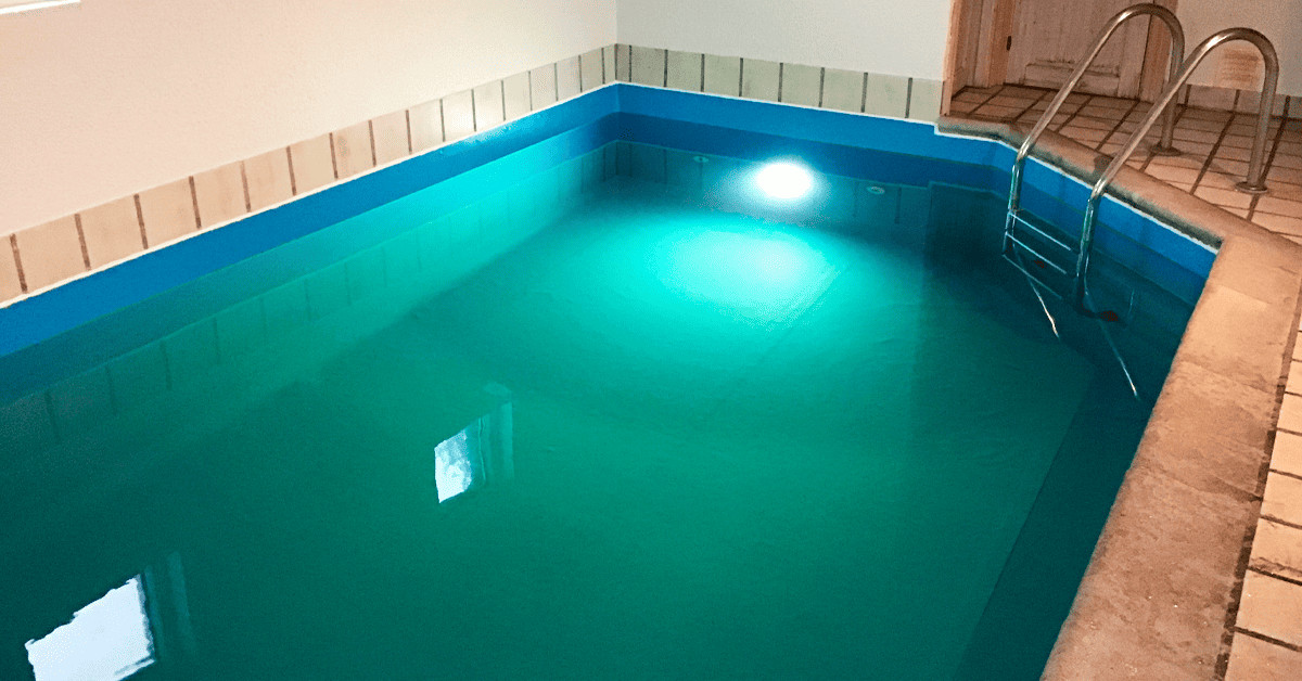 Swimmingpool med vand efter at pool lineren er blevet skiftet. Vandet har et grønt skær indtil det har været igennem klordosering.