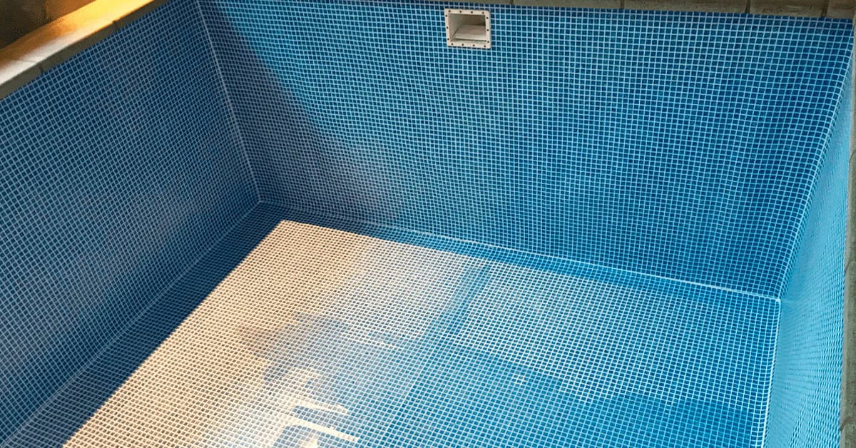 Bassin væg med mosaik folie. Indendørs swimmingpool har fået beklædning med blå mosaik folie. Her står poolen helt færdig.
