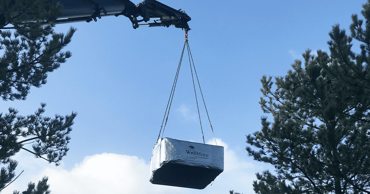 Levering af en MaXXwell Laidback udespa i luften. Per normalvis kranes disse spa ind, hvis den skal på husets terrasse. Det er også tilfældet her.