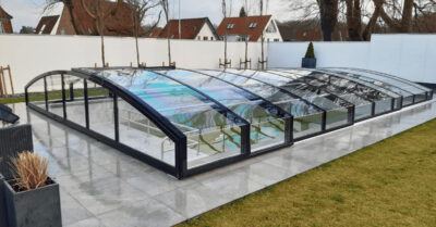 Smukt teleskoptag over swimmingpool. Tager er model carat fra Vöroka med sorte panelspær, der passer til husets indfatninger|Vöroka pooloverdækning model Carat. Stilrent og smukt teleskoptag til swimmingpool sat op i have.
