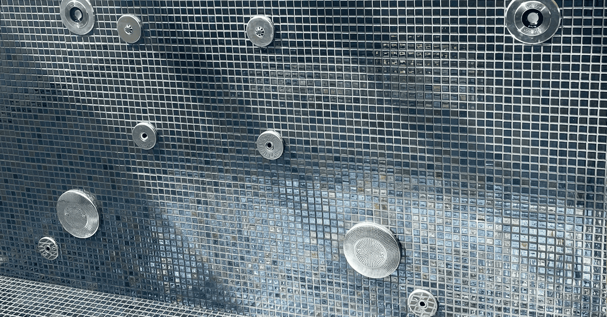 Indstøbning i sølv ved mosaikpool. Alt er udført i samme stil og skinnede udtryk, så himlen kan spejle sig og give vandet et skær efter sæsonen